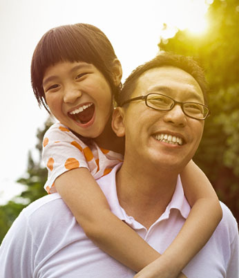 Pai e filha sorrindo, apresentando saúde bucal com planos odontológicos individuais e para empresas.