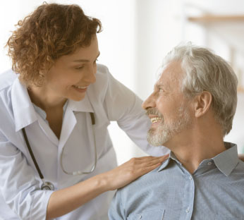 Médica confortando paciente idoso participante dos Programas de Medicina Preventiva Notredame Intermédica.