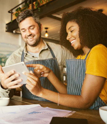 Colegas no trabalho aparecem felizes com as soluções de planos de saúde para pequenas, médias e grandes empresas.