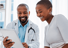 Homem e mulher afrodescendente olhando a tela de um tablet