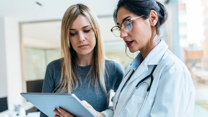Duas mulheres uma ao lado da outra olhando para o tablet